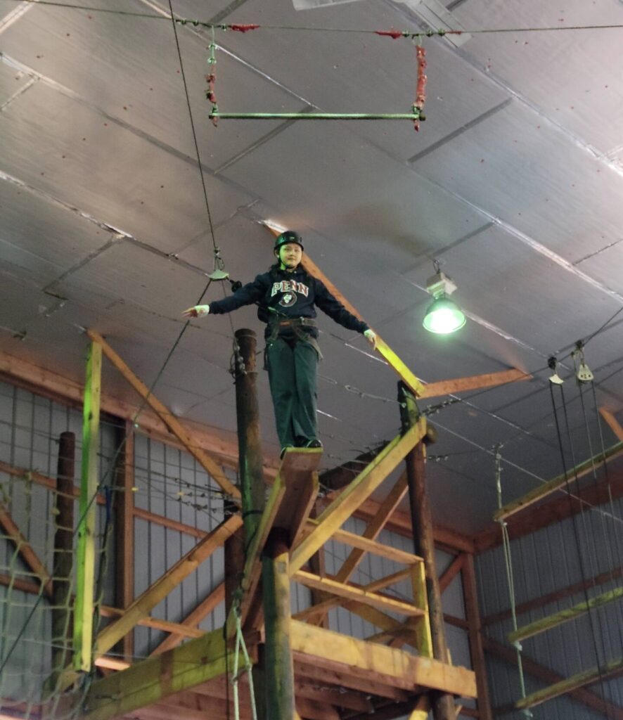 4th Class Midshipman Wang prepares to take a "leap of faith" at the high ropes course.