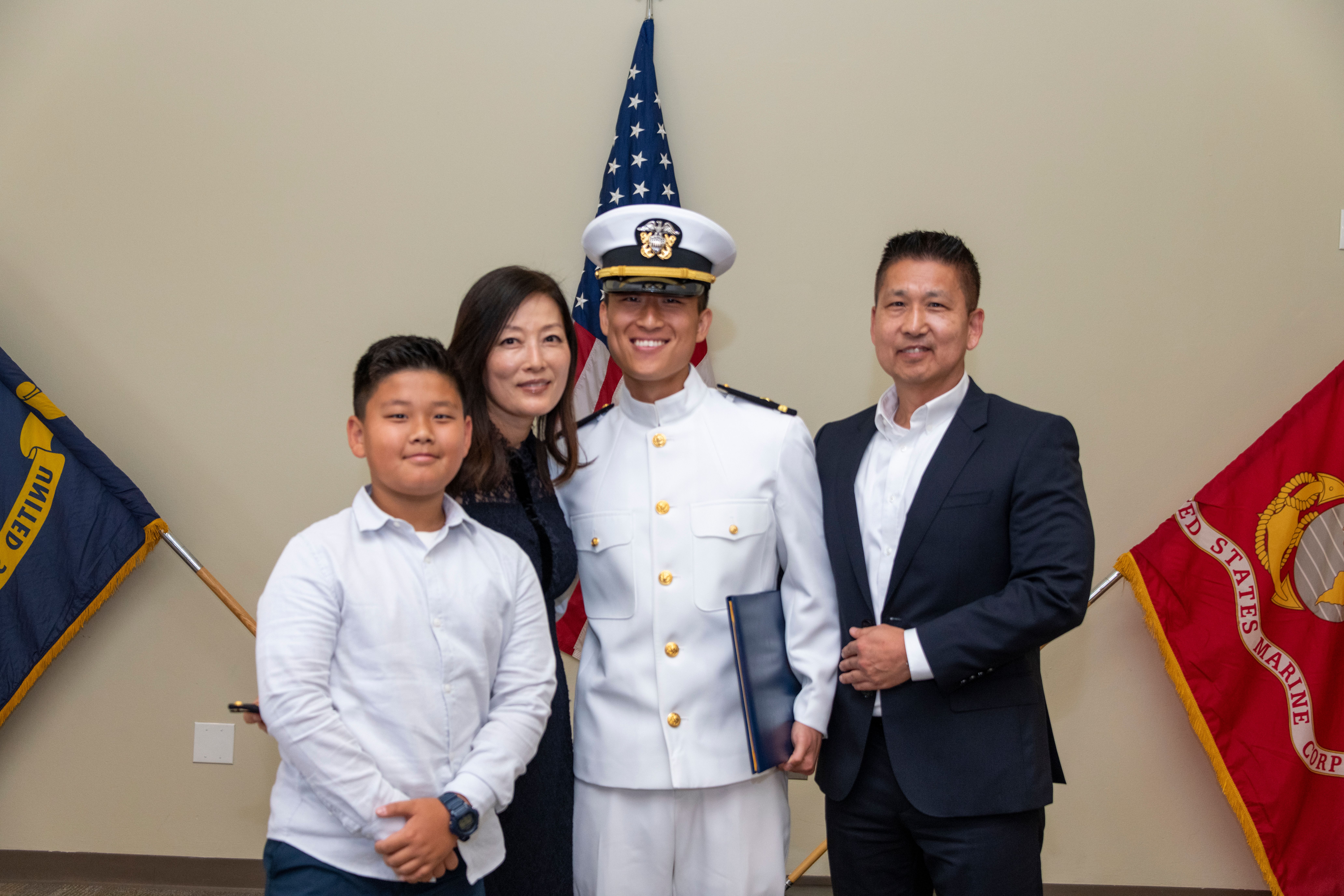 ENS Chung stands with his family with his commission warrant in hand